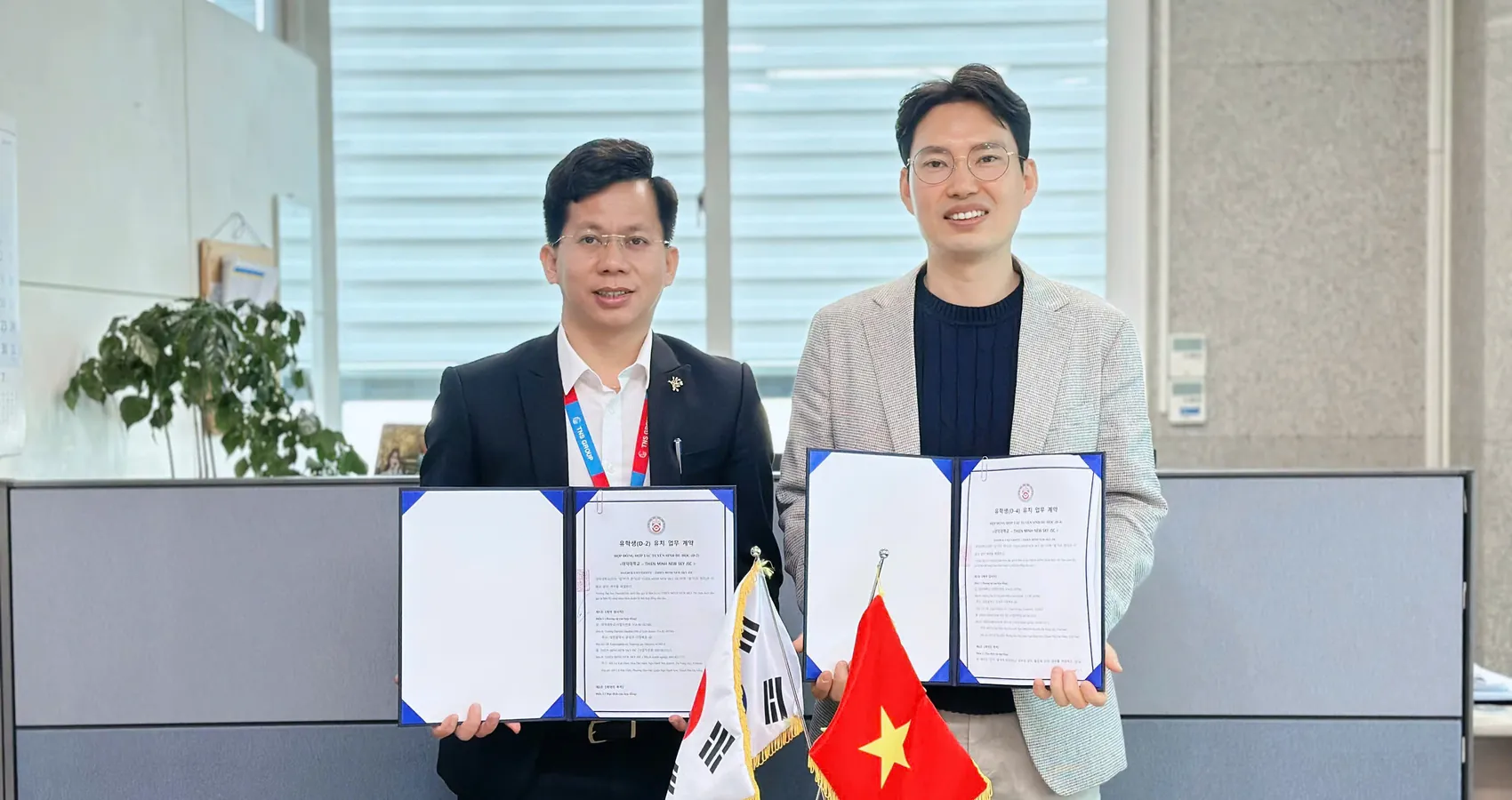 Đại diện TNS Group và Đại học Daeduk (Hàn Quốc) cầm văn bản ký kết hợp tác